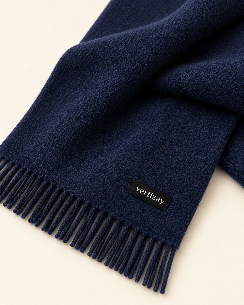 Close-up of the navy Northline scarf showing fringe, woven texture and vertizay label.