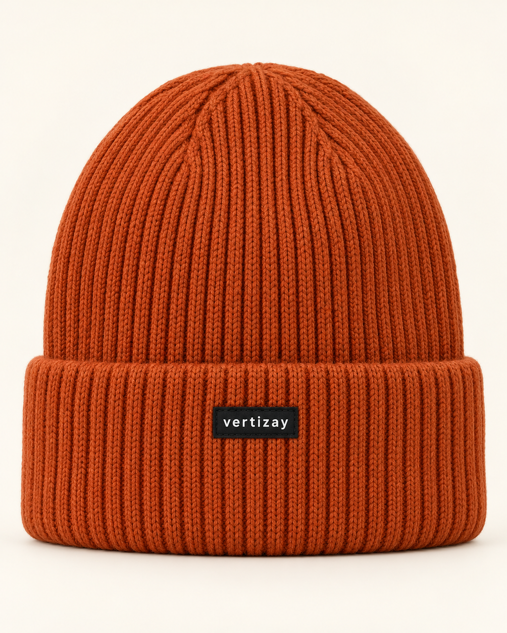 Rust Summit rib-knit beanie with folded cuff and centered vertizay label, front view.